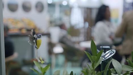 Shot-of-realistic-hummingbird,-hovering-fake-grass,-garden-decor,-solar-energy-powered