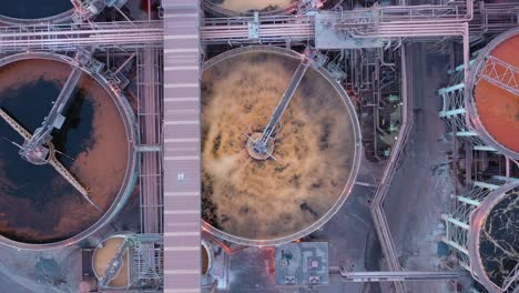 Top-down-drone-shot-of-metal-and-coal-factory-waste-or-water-purification-tank,-Queensland-Australia-4K