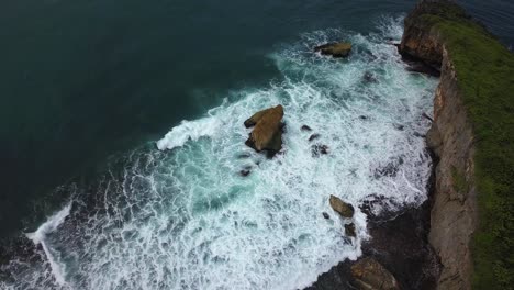Blick-Von-Oben-Auf-Die-Küste-Mit-Riesigen-Korallenfelsen-Mit-Gruppen-Kleiner-Felsen,-Die-Von-Der-Welle-Getroffen-Werden