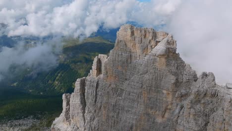 Orbiting-drone-shot-of-rocky-Brenta-mountain-with-foggy-mountain-range-in-background-at-sunlight