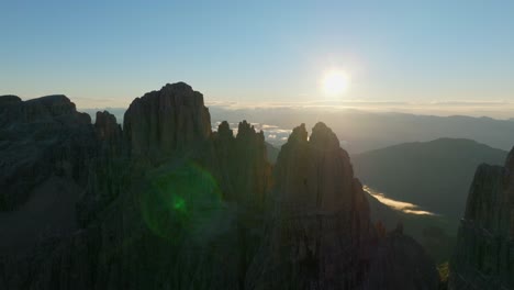 Aerial-view-showing-silhouette-of-Dolomite-Mountain-peak-and-sunset-in-background-at-horizon