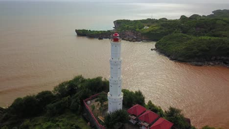 Baron-Beach-lighthouse-on-hilltop-protecting-ships-from-dangerous-rocks-in-Indonesia