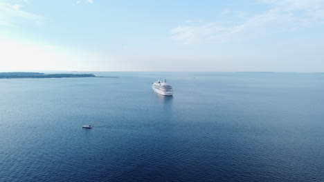 Aerial-Seascape-with-Cruise-Ship-and-Small-Boat-Sailing,-Sunny-Day