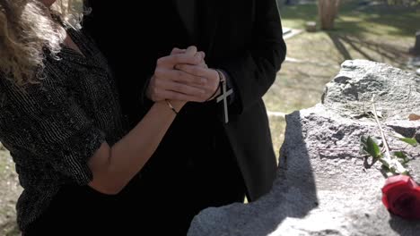 Husband-and-wife-are-mourning-their-loved-ones-in-front-of-their-grave