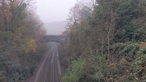 Nebel-Neblige-Bahngleise-Führen-Zum-Tunnel-Mit-Umliegendem-Waldwald-Uk-4k