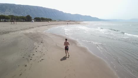 Man-jogging-on-the-beach-alone