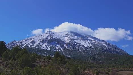 Schneebedeckter-Berggipfel-Und-Sich-Bewegende-Wolken-über-Der-Spitze