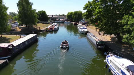 Aerial-view-of-a-motor-boat-cruising-along-the-River-Great-Ouse-in-Ely,-Cambridgeshire,-UK