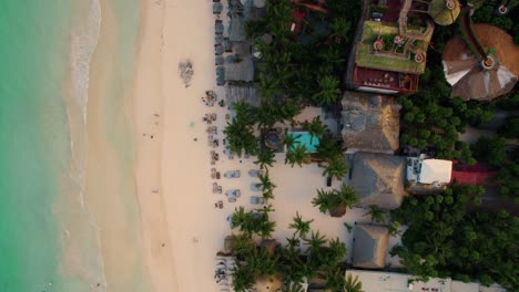 Aerial-view-of-a-tourist-resort-along-a-beautiful-white-sand-beach-and-transparent-water