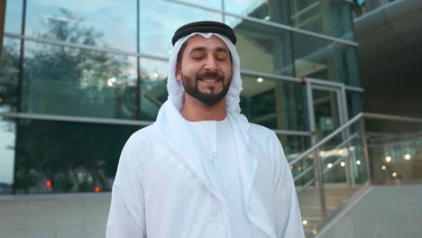 Portrait-of-happy-Arab-man-with-modern-business-background