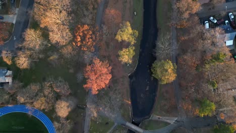 An-aerial,-top-down-view-high-over-a-colorful-park-during-the-fall-season-on-a-sunny-day