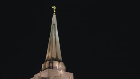 Goldene-Statue-Auf-Der-Turmspitze-Des-Kirchengebäudes-Des-Mormonentempels-Der-LDS-Bei-Nacht,-Beleuchtet-Von-Warmem-Licht-In-Gilbert,-Arizona
