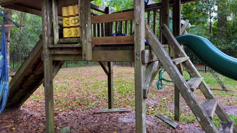 Old-creepy-looking-outdoor-jungle-gym-playset-in-yard-with-swing-and-slide