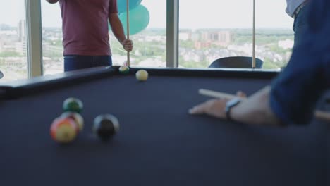 Anonymous-office-colleagues-playing-pool-in-coworking-office-building-during-lunch-hour