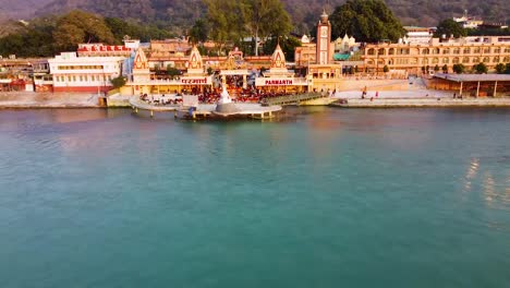 holy-ganges-riverbank-filled-with-religious-temples-at-evening-aerial-shot-video-is-taken-at-parmarth-ashram-rishikesh-uttrakhand-india-on-Mar-15-2022