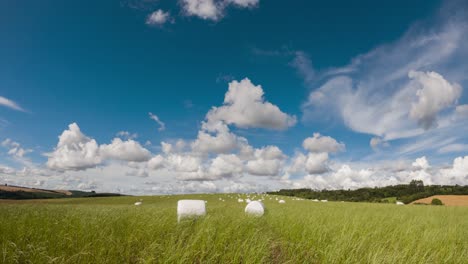 Movement-of-clouds-and-wind-in-the-field-with-haylage-roll-silage,-time-lapse-clip
