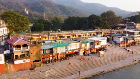 holy-ganges-riverbank-filled-with-religious-temples-at-evening-aerial-shot-video-is-taken-at-rishikesh-uttrakhand-india-on-Mar-15-2022