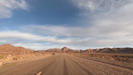 Driving-Death-Valley-National-Park-on-asphalt-road-with-mixed-clouds-in-sky
