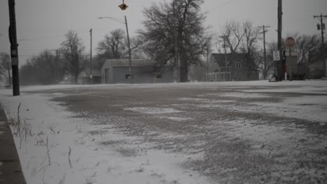 Snow-blows-on-the-street-in-a-small,-quiet,-quaint-town-in-the-midwest-in-Kansas-on-a-cold,-December,-winter-day-during-Christmas,-holidays