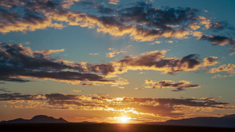 Sonnenuntergang-Im-Zeitraffer-über-Dem-Zerklüfteten-Gelände-Der-Mojave-Wüste-Mit-Den-Bergen-Als-Silhouette