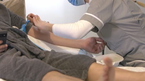 Nurse-preparing-patients-arm-rubbing-antiseptic-wipe-before-taking-blood-from-vein