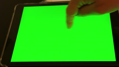 man-works-on-tablet-green-screen-in-office