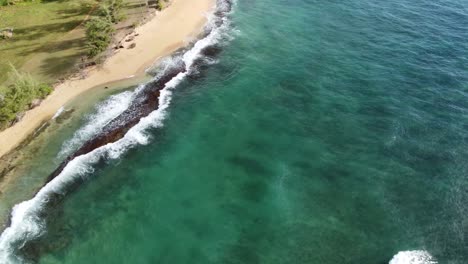 Türkisfarbenes-Ozeanwasser,-Das-Am-Ufer-Schäumt,-Den-Goldenen-Sand-Des-Strandes-Mit-Fußspuren-Wäscht,-Idyllischer-Sommerurlaub-In-Hawaii