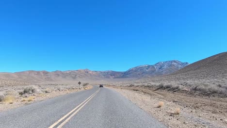 Death-Valley-Nationalpark-Fahrt-Auf-Asphaltierter-Straße-Mit-Bergen-Und-Blauem-Himmel
