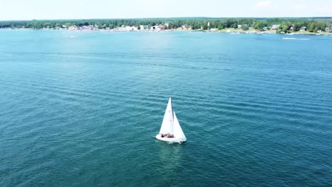Aerial-Orbit-of-Sailboat-in-summer-sun---Hessel,-Michigan---Lake-Huron
