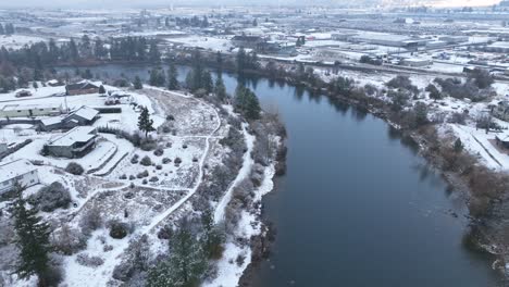 Drone-shot-of-the-Spokane-River-surrounded-by-a-blanket-of-snow