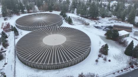 Orbiting-aerial-view-of-two-large-reservoir-structures-during-the-Spokane-winter