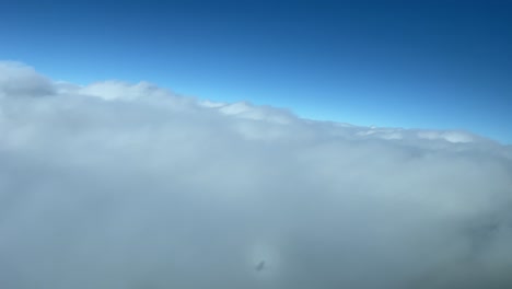 Aerial-view,-pilot-point-nof-view,-of-the-halo-of-a-jet-plane-overflying-clouds-during-a-left-turn-with-a-deep-blue-sky