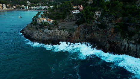 Port-de-Sóller-Waves-Crashing-On-Cliffs-During-Summer-Storm-Dramatic-Tilt-Down-Aerial-View-in-Mallorca