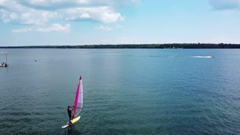 Windsurfer-Going-Out-To-Sea---Aerial-Follow---Lake-Huron---Hessel,-Michigan