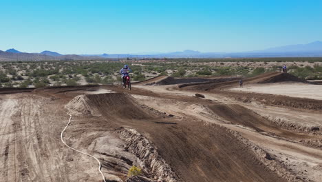 Motorcyclist-makes-a-high-jump-on-a-dirt-racetrack-in-slow-motion-as-seen-from-a-drone