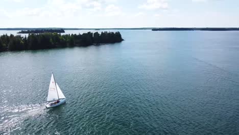 Following-Aerial-of-Sailboat-in-summer-sun---Hessel,-Michigan---Lake-Huron