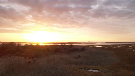 A-low-altitude-time-lapse-over-a-salt-marsh-on-Long-Island,-NY-at-sunrise