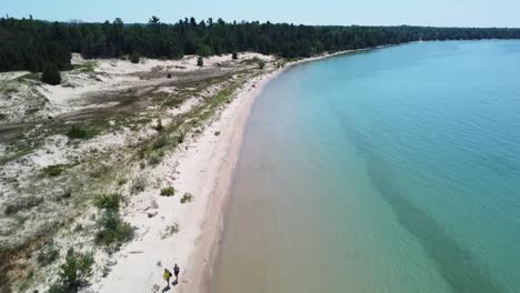 Aerial-Two-Walking-on-Beach---Fisherman-Island,-Michigan