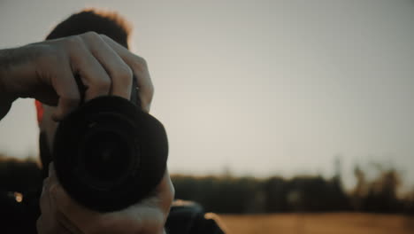 Close-up-tracking-arc-shot-of-the-face-and-DSLR-or-mirrorless-camera-with-lens