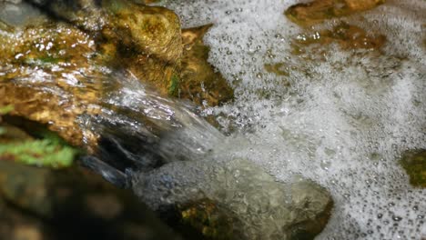 Fresh,-clean,-crystal-clear-water-flowing-over-rocks-in-a-babbling-brook---isolated-close-up