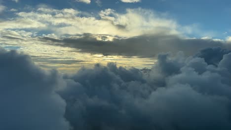 Aerial-view-from-a-jet-cockpit,-pilot-point-of-view-during-a-flght-through-winter-clouds-at-sunset