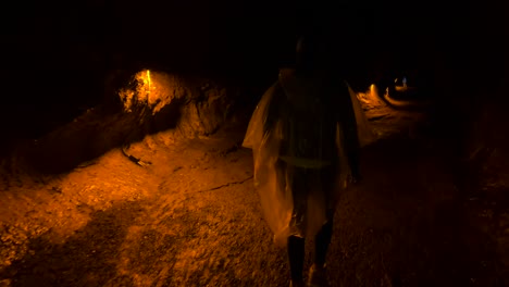 Mauna-Loa-volcano,-woman-walking-down-path-in-dark-tunnel-in-Hawaii