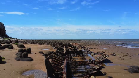 Close-aerial-view-of-an-old-ship-wreck-rusting-away-on-the-beach-at-Hunstanton,-Norfolk,-UK