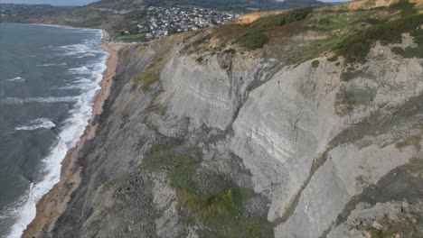 Slow-aerial-approach-of-the-massive-cliff-sides-of-the-Charmouth-Beach-hills