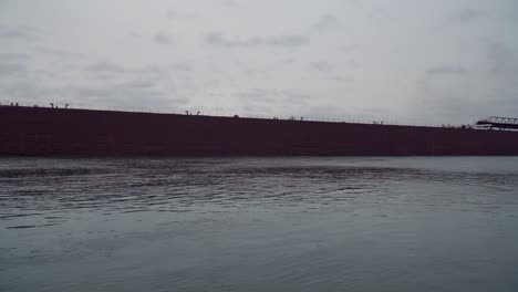 Static-shot-of-a-very-long-ship-moving-past,-upstream