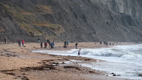 people-enjoy-being-on-a-beach-made-of-Pebbles-in-the-south-of-England,-Dorset