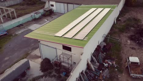 Green-renewable-warehouse-with-photovoltaic-solar-panel-installed,-aerial