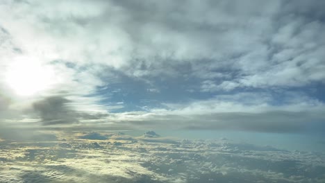 Aerial-view-from-a-jet-cockpit-of-a-winter-sky-plenty-of-colorful-clouds,-yellow-and-white-colors,-before-sunset