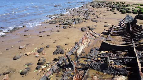 Aerial-view-of-an-old-ship-wreck-rusting-away-on-the-beach-at-Hunstanton,-Norfolk,-UK