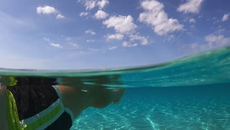 Persönliche-Perspektive-Von-Menschenbeinen-Und-Füßen,-Die-Auf-Wunderschönem-Klarem-Und-Transparentem-Meerwasser-Der-Türkisfarbenen-Lagune-Auf-Der-Tropischen-Insel-Schwimmen